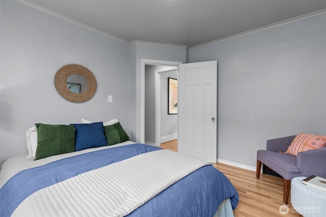 bedroom with light wood-type flooring, baseboards, and ornamental molding