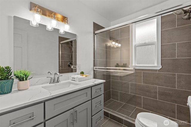 full bath with tiled shower, toilet, and vanity