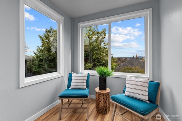 living area with plenty of natural light, wood finished floors, and baseboards