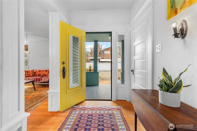 foyer entrance with light wood-style floors and ornate columns