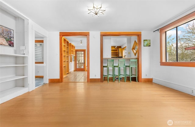 interior space with built in features, baseboards, and wood finished floors