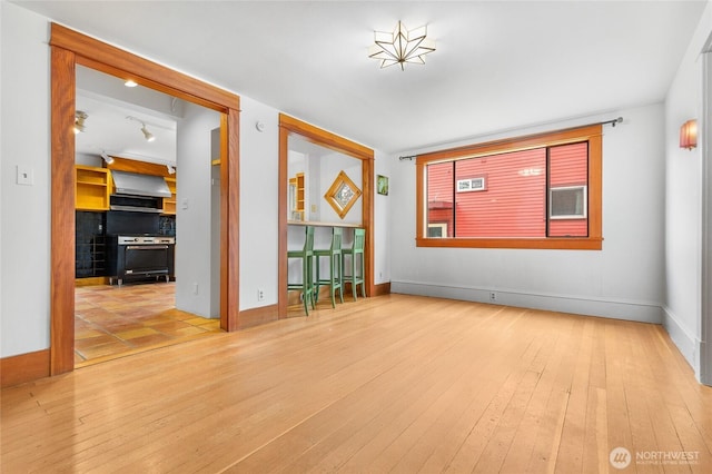 empty room with baseboards and wood-type flooring