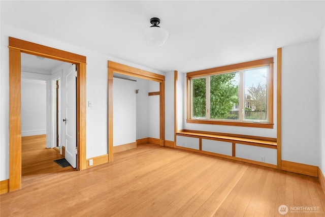 unfurnished bedroom with light wood-type flooring, baseboards, a closet, and visible vents