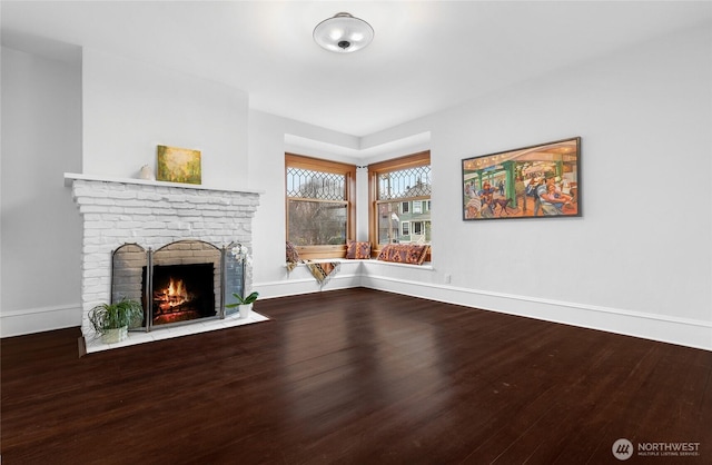 unfurnished living room featuring wood finished floors, a fireplace, and baseboards