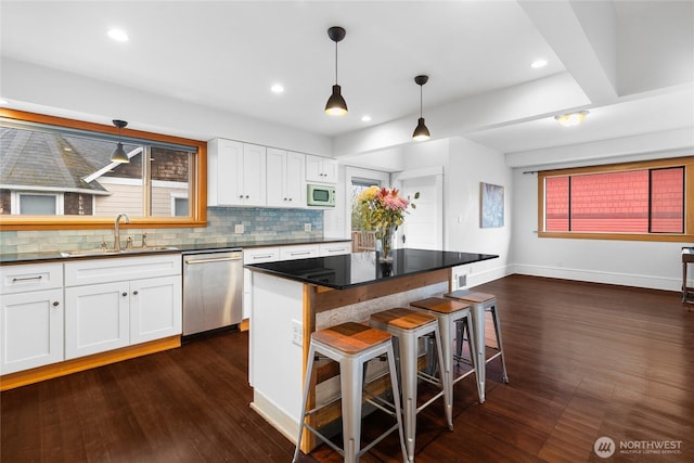 kitchen with a sink, dark countertops, white cabinetry, white microwave, and dishwasher