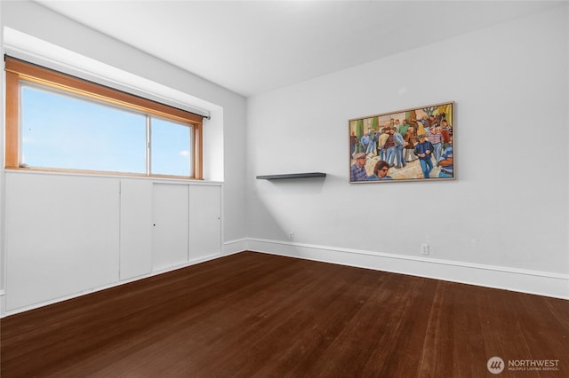 unfurnished room with wood finished floors and baseboards