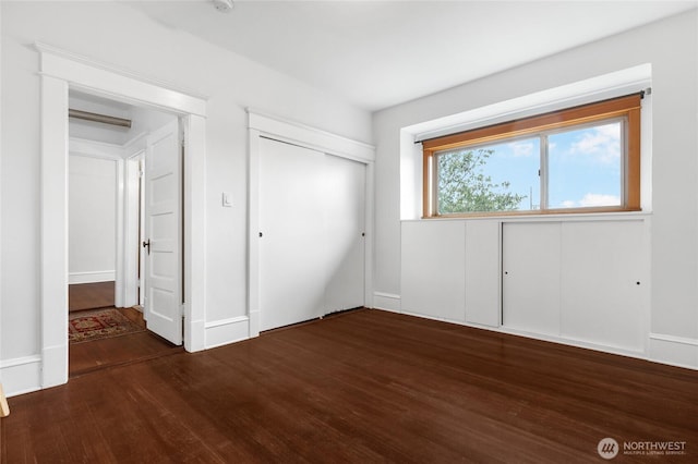 unfurnished bedroom featuring dark wood-style flooring and a closet