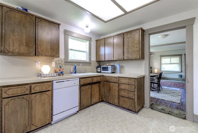 6845 S Clement Ave, Tacoma, WA 98409 - kitchen featuring white dishwasher, light countertops, light flooring, and a sink