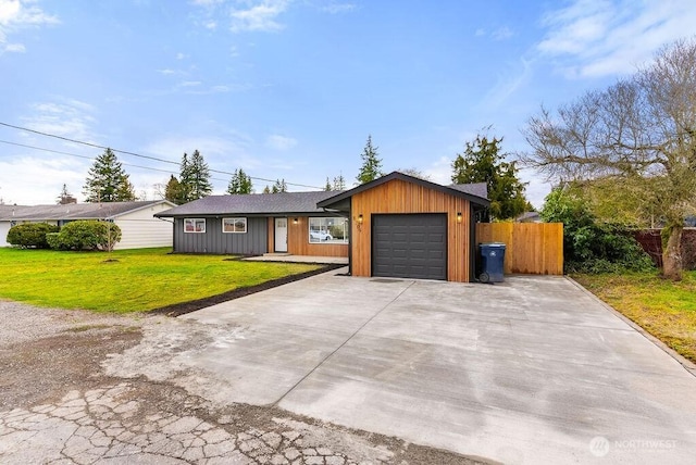 view of front of home featuring driveway, an attached garage, a front lawn, and fence