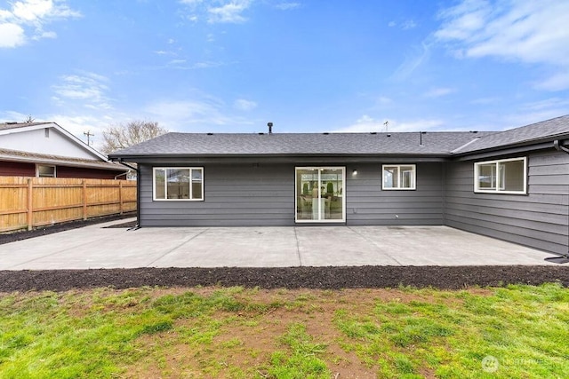 rear view of property featuring a patio and fence