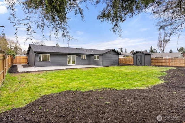 rear view of property featuring a yard, a fenced backyard, an outdoor structure, a storage unit, and a patio area