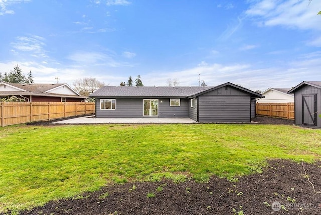 back of property featuring a yard, a patio, an outdoor structure, and a fenced backyard