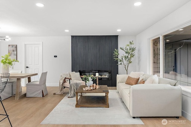 living area featuring recessed lighting, baseboards, and light wood-style floors