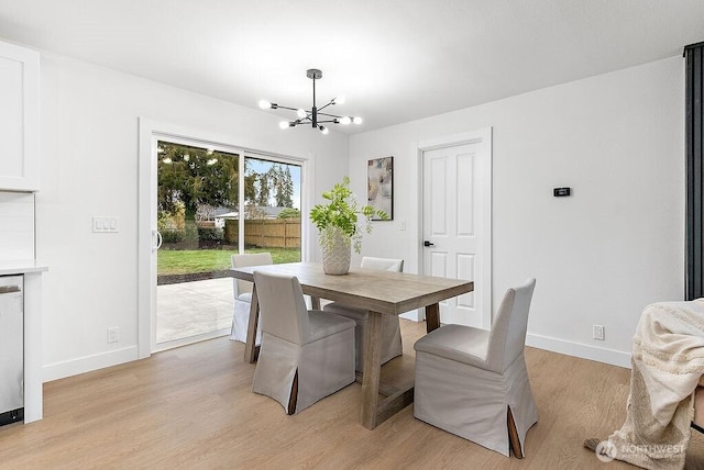 dining room with a notable chandelier, light wood-style flooring, and baseboards