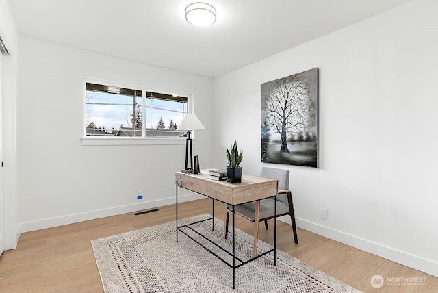 office space with visible vents, light wood-type flooring, and baseboards