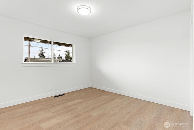 spare room with visible vents, baseboards, and light wood finished floors