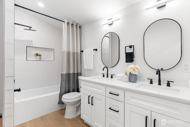 full bathroom with a sink, shower / bath combo with shower curtain, toilet, and wood finished floors