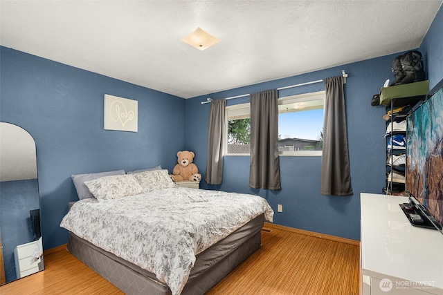 bedroom featuring wood finished floors and baseboards