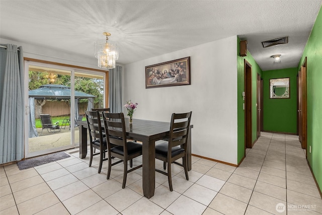 dining space featuring visible vents, baseboards, an inviting chandelier, light tile patterned flooring, and a textured ceiling