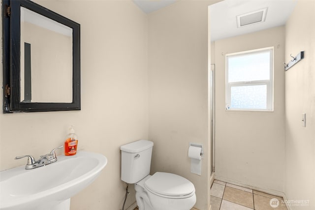 bathroom featuring a sink, visible vents, toilet, and tile patterned floors