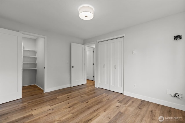 unfurnished bedroom with baseboards, a closet, and light wood finished floors