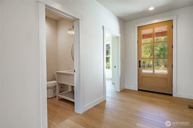 foyer with light wood finished floors, visible vents, recessed lighting, and baseboards