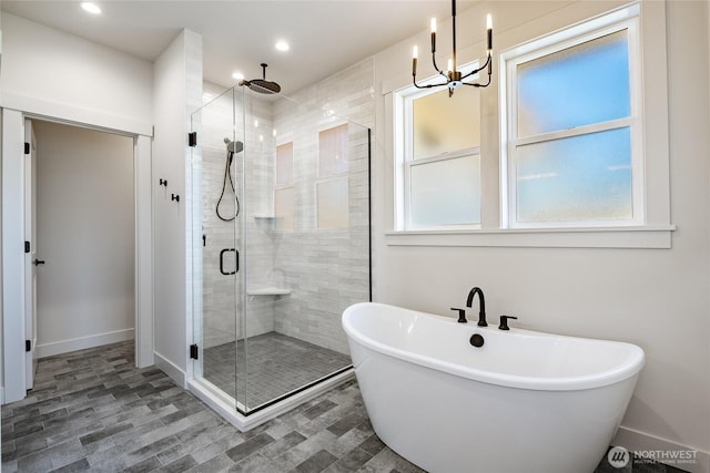 full bathroom with recessed lighting, a stall shower, a freestanding bath, and baseboards