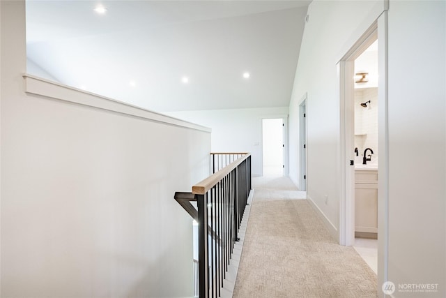 hall featuring recessed lighting, light carpet, and an upstairs landing