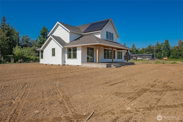 view of front facade featuring roof mounted solar panels and a porch