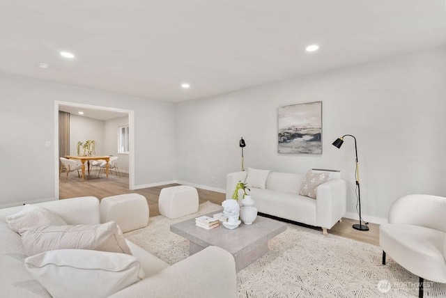 living room featuring recessed lighting, baseboards, and wood finished floors