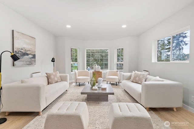 living area with recessed lighting, wood finished floors, and a wealth of natural light