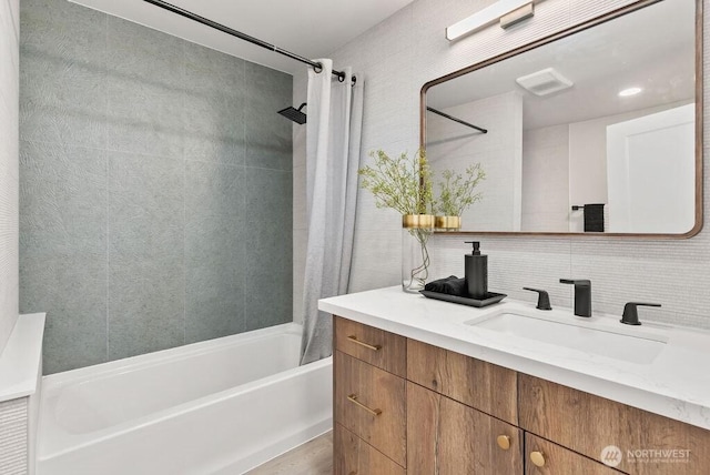 bathroom featuring shower / bath combo with shower curtain, backsplash, and vanity