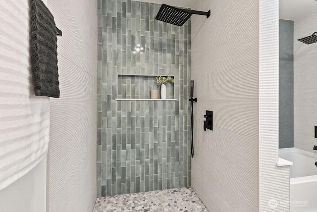 bathroom featuring a tile shower and a washtub