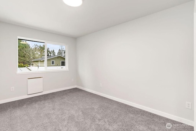 spare room featuring baseboards and carpet