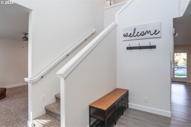 staircase featuring baseboards and wood finished floors