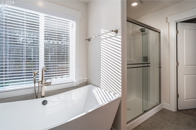 full bathroom featuring tile patterned flooring, a shower stall, and a healthy amount of sunlight