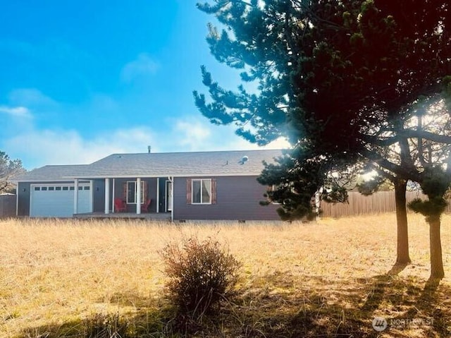 ranch-style home featuring an attached garage, fence, and crawl space