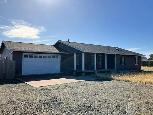 ranch-style house featuring driveway, a porch, fence, roof with shingles, and an attached garage