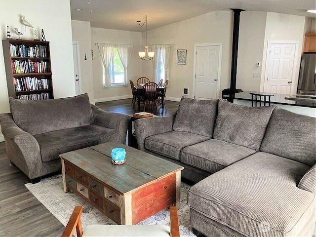 living area featuring baseboards, wood finished floors, an inviting chandelier, and vaulted ceiling