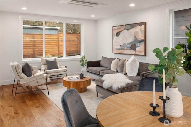 living room with recessed lighting, wood finished floors, visible vents, and baseboards