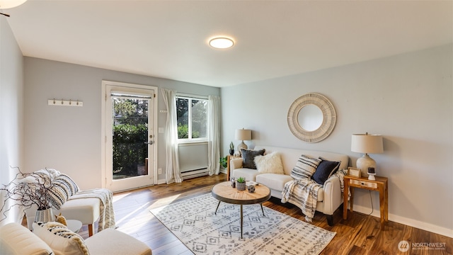 living room with a baseboard heating unit, baseboards, and wood finished floors