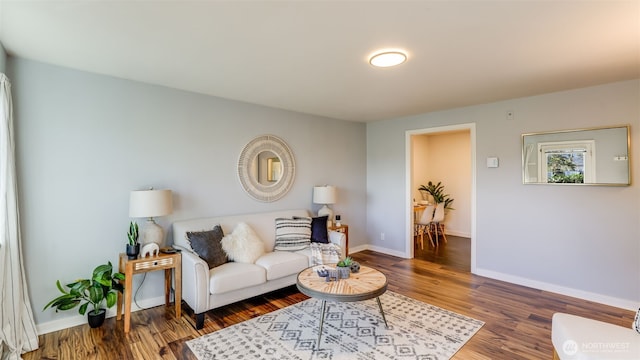 living area with baseboards and wood finished floors