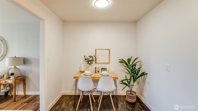 dining area with baseboards and wood finished floors