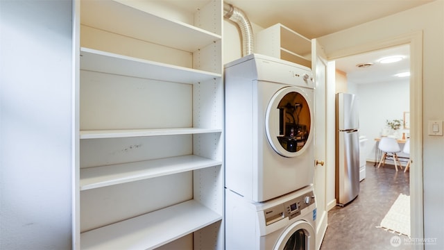 laundry area with stacked washer and dryer