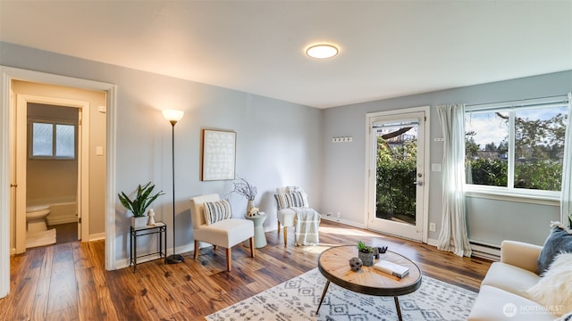 sitting room with wood finished floors, baseboards, and a baseboard radiator