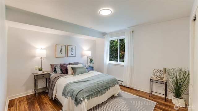 bedroom featuring baseboards, baseboard heating, and wood finished floors