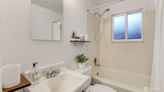 bathroom with a sink, shower / bathtub combination with curtain, and toilet