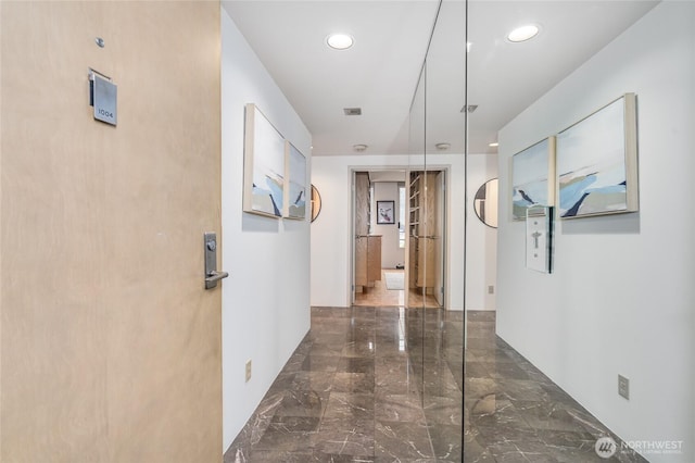 hall featuring recessed lighting and marble finish floor