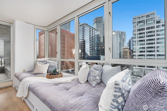 bedroom featuring a view of city and wood finished floors