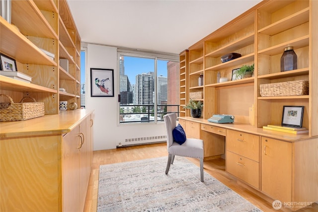 home office featuring a view of city, light wood-style flooring, and built in desk